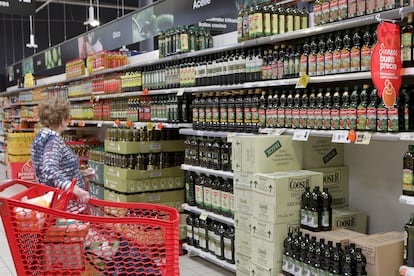 Una clienta, delante de los lineales de aceite de oliva en un supermercado Eroski.