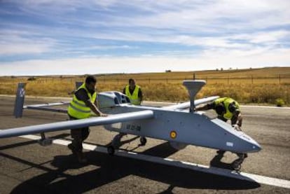 De arriba abajo, técnicos del INTA inspeccionan drones con sensores visibles e infrarrojos, destinados a misiones de reconocimiento y vigilancia; un piloto guía una aeronave robótica desde la cabina de mando en tierra, y operarios revisan un Searcher MKII J en León.