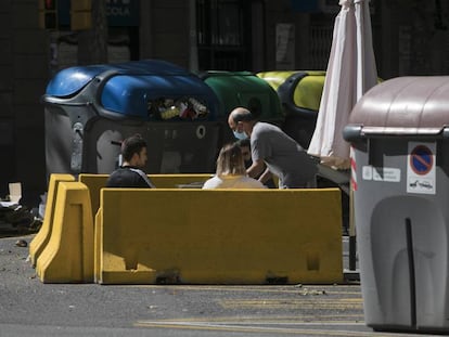 Una terrassa d'un bar al carrer Aragó, situada entre contenidors. 