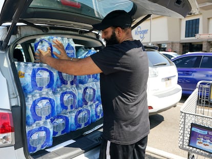 Rajwinder Singh, dueño de una gasolinera con tienda de conveniencia, mete en su coche cajas de agua recién compradas en un hipermercado en Jackson (Misisipi).
