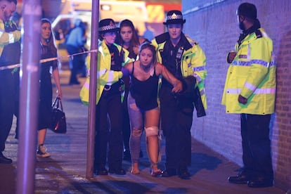 Una joven herida es atendida por miembros de la policía tras el atentado ocurrido durante el concierto de Ariana Grande en el Manchester Arena.