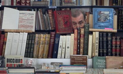 Un librero muestra sus existencias en su puesto del paseo de Recoletos.