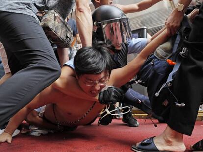 Policías detienen a un hombre tras un enfrentamiento entre manifestantes contra el Gobierno y partidarios en Pekín, el sábado pasado en Hong Kong.