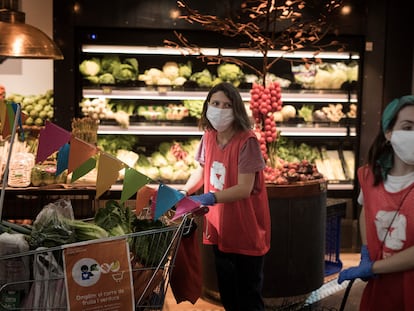 Dos voluntarias de la ONG De Veí a veí recogiendo alimentos en el mercado de Sant Antoni.