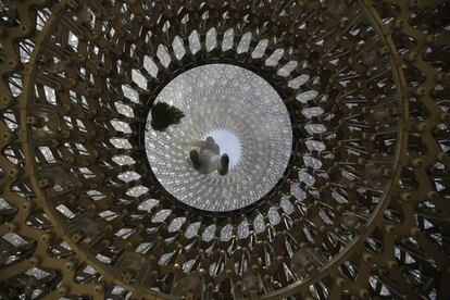 Un trabajador limpia la instalación del artista británico Wolfgang Buttress 'La Colmena', en el Real Jardín Botánico de Kew, al oeste de Londres (Reino Unido).