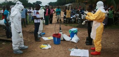 Los voluntarios de Cruz Roja se preparan para entrar a la casa de una supuesta víctima del ébola.