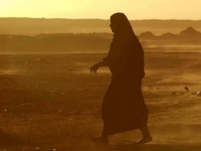 Una mujer camina por el desierto en medio de una tormenta.