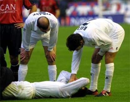 Zidane y Raúl se procupan por Figo, tendido en el campo, durante un partido.