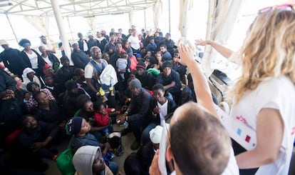 Personas del MSF explican a los migrantes como bajar del barco tras llegar al puerto de Valencia.
