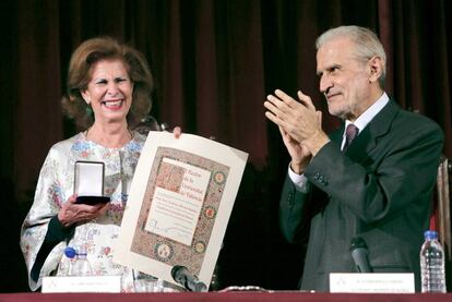 Alborch muestra la medalla de la Universitat en el Paraninfo de La Nau.