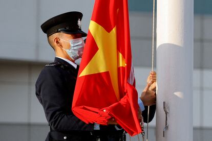 Un policía sostiene una bandera china en Hong Kong este domingo