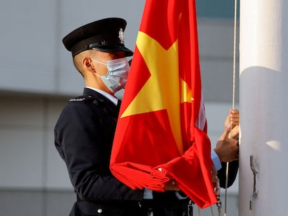 Un policía sostiene una bandera china en Hong Kong este domingo