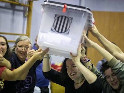 Un grupo de personas sostiene una urna en un colegio de Barcelona durante el referéndum del 1 de octubre de 2017.