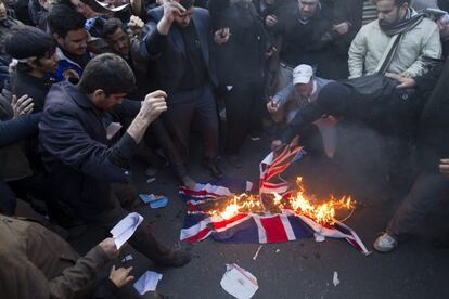 Manifestantes queman la Union Jack, a las puertas de la legación británica.