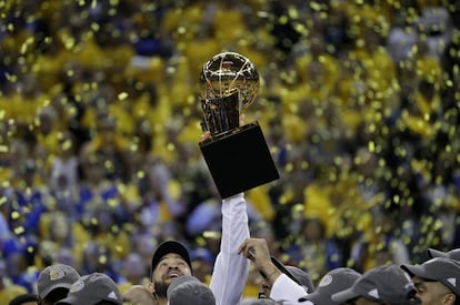 El jugador de los Warriors JaVale McGee levanta el trofeo.