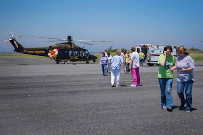 Sin hospital en la isla, las familias observan cómo una residente local es llevada en helicóptero debido a un dolor de pecho.