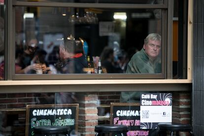 Un cliente de un bar del centro de Barcelona mira por la ventana.

