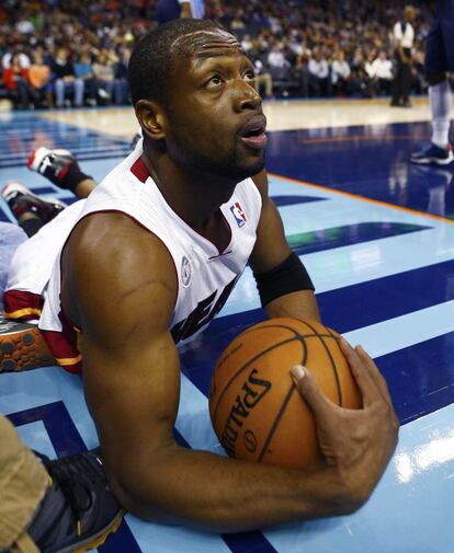 Dwyane Wade agarra la bola en el suelo en el partido contra los Charlotte Bobcats.