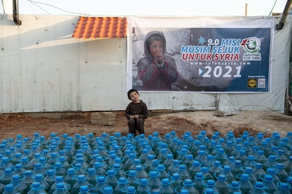 Un menor refugiado sirio aguarda la distribución de combustible por una ONG malaya en un asentamiento informal de Arsal