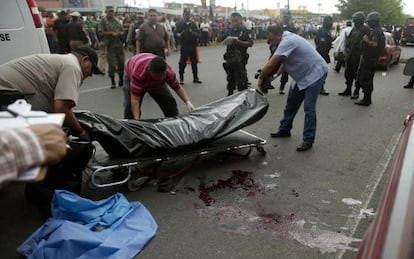 Forensic experts transfer the bodies of two police officers murdered in Culiacán.