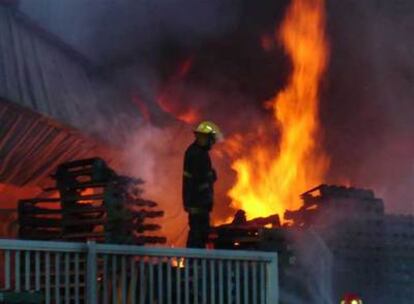 Los bomberos atajan el incendio provocado en la pesquería española Arbumasa.
