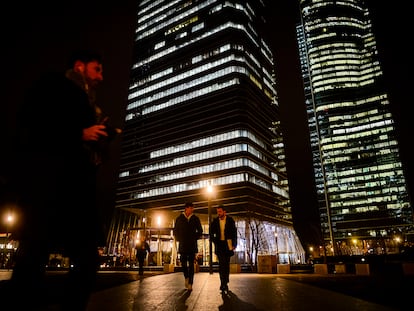 Dos jóvenes pasean frente a la zona de las cuatro torres empresariales de Madrid.