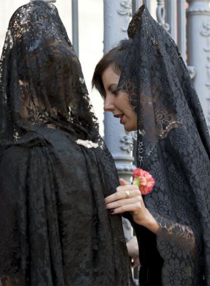 Mujeres con mantilla y peineta, en el Jueves Santo de Sevilla.