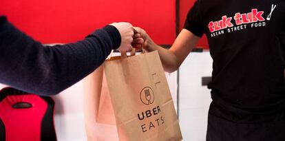 Un repartidor hace entrega de un pedido a domicilio del restaurante Tuk Tuk.