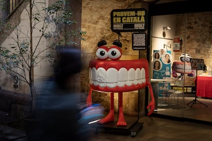 Queta, la mascota lingüística con forma de dentadura para promover hablar en catalán, en las puertas de la sede del Consorcio. 
