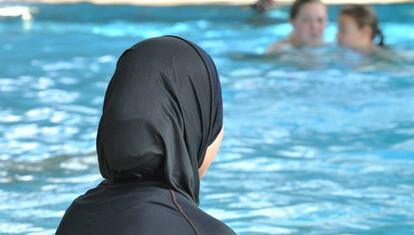 Una mujer con burkini en una piscina.