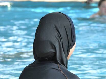 Una mujer con burkini en una piscina.