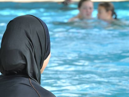 Una mujer con burkini en una piscina.