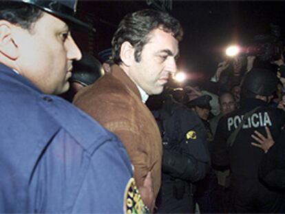 Dante Peirano es escoltado por la policía tras testificar en un tribunal.