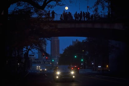 Un grupo de gente contempla el efecto de la 'superluna' sobre las calles de Manhattan.