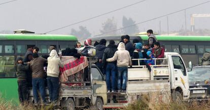 Um grupo de sírios abandona, na sexta-feira, os bairros rebeldes de Aleppo.