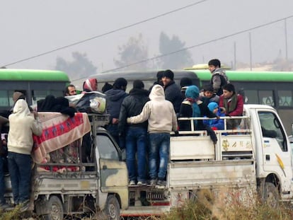 Um grupo de sírios abandona, na sexta-feira, os bairros rebeldes de Aleppo.