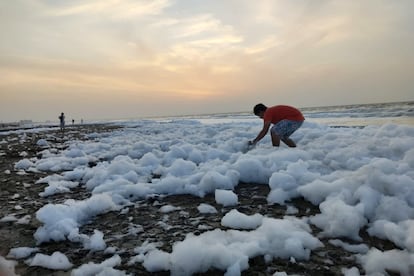 Un joven juega con la espuma a la orilla de una playa en Coatzacoalcos, Veracruz.