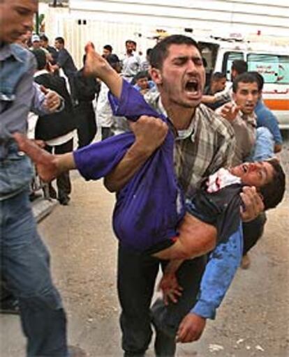 Un palestino transporta el cadáver de un niño fallecido en el ataque con misiles contra una manifestación.