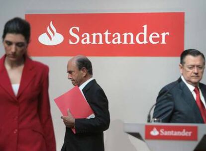 Emilio Botín, carpeta en mano, abandona el estrado tras la presentación de resultados del Santander, en presencia de Alfredo Sáenz.