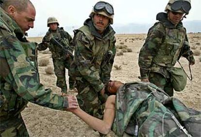 Marines estadounidenses trasladan en una camilla a un soldado iraquí herido cerca de Basora