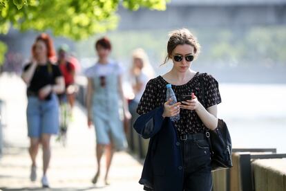 Una chica consulta su teléfono mientras pasea en Moscú.