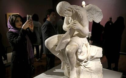 Una mujer junto a la escultura 'Funerary Genius' en la exposición 'El Louvre en Teherán', inaugurada el 5 de marzó en Teherán.
