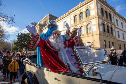 Los Reyes magos saludan desde su coche en su llegada a San Sebastián, por la antigua Fabrica de Tabakalera, actual centro cultural.
