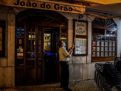 Un camarero cierra las persianas de un restaurante en el centro de Lisboa el 9 de noviembre de 2020.