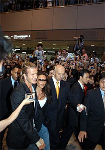 Una multitud recibe a Beckham y su mujer, ayer en el aeropuerto de Tokio.