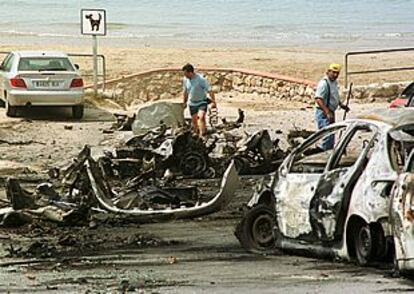 Estado en que quedó el coche bomba y los que estaban aparcados junto a él.