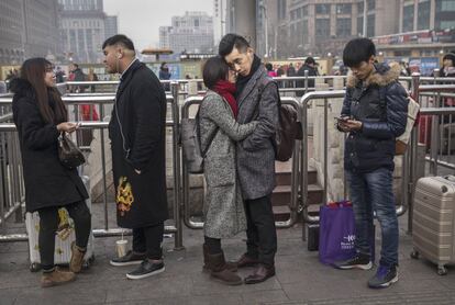 Una pareja se despide antes de separarse en la estación de tren de Pekín.