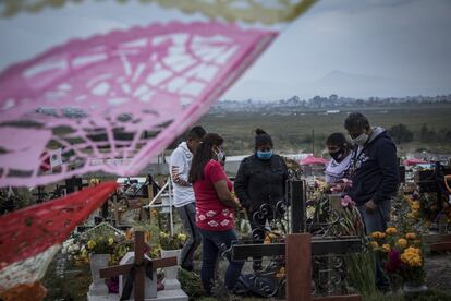 Una familia hace guardia en la tumba de un familiar en el cementerio de Xico. 