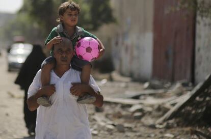 Un palestino lleva a hombros a su hijo en el este de Gaza.