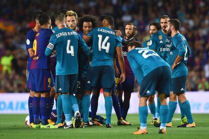 Los jugadores del Barcelona discuten con los jugadores del Real Madrid.